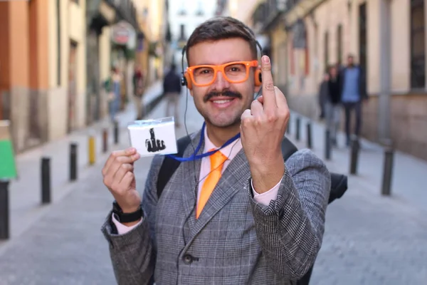 ストリートで中指を示すヘッドフォンや眼鏡を持つジャケットのハンサムな若い男のクローズアップ肖像画 — ストック写真