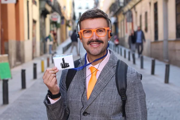 ストリートで中指を示すヘッドフォンや眼鏡を持つジャケットのハンサムな若い男のクローズアップ肖像画 — ストック写真