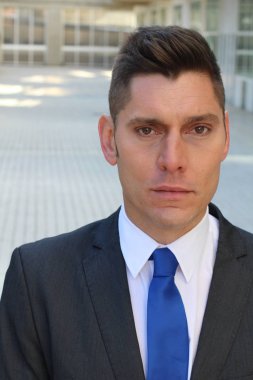 close-up portrait of handsome young businessman in suit on street