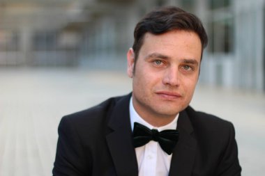 Siyah takım elbiseli, papyonlu yakışıklı bir gencin yakın plan portresi.