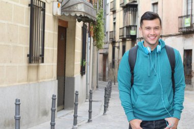 Genç etnik adam dışarıda teknoloji kullanıyor.