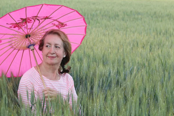 Volwassen Vrouw Met Een Roze Paraplu Tijdens Zonnige Dag — Stockfoto