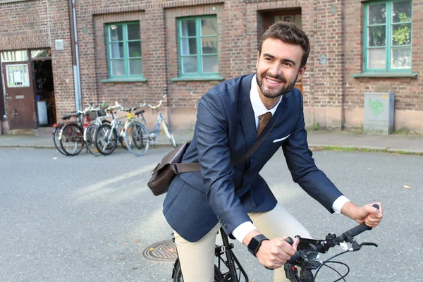 Handsome businessman heading to work by bike