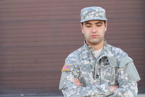 close-up portrait of handsome young soldier on brown wall background