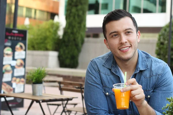 穿着休闲装 街上有橙汁的英俊年轻人的特写 — 图库照片