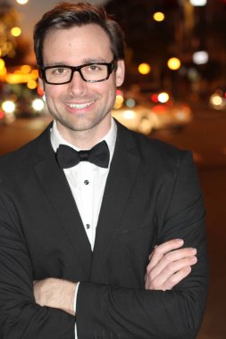 smokinli ve papyonlu yakışıklı bir delikanlının akşam vakti şehir caddesinde yakın plan fotoğrafı.