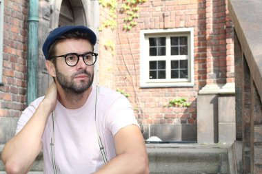 Sokakta şık giyinmiş yakışıklı bir gencin yakın plan portresi.