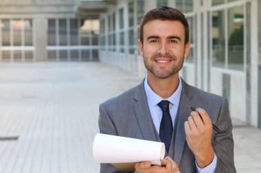 Sokakta gri takım elbiseli yakışıklı genç işadamının yakın plan portresi.