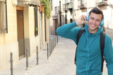 Genç etnik adam dışarıda teknoloji kullanıyor.