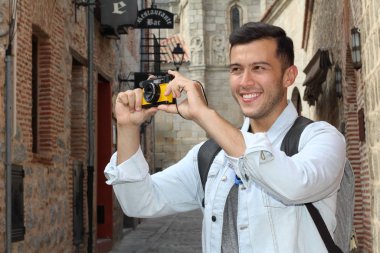 Klasik kamerayla fotoğraf çekmek için yaratıcılığını kullanan bir adam.