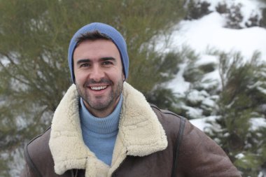 Kışın sıcacık giysiler içindeki yakışıklı genç adamın yakın plan portresi.