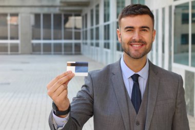 Banka kartı olan yakışıklı genç iş adamının yakın plan portresi.