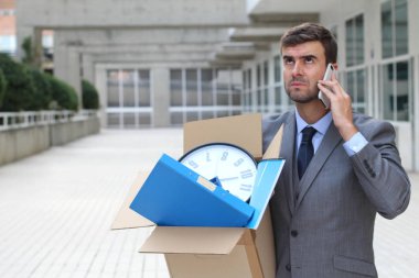 Depresyondaki işadamı eşyalarını taşıyor.