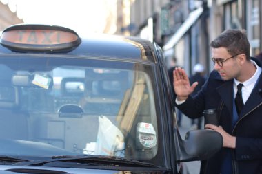 Sokakta taksiye binen yakışıklı genç adamın yakın plan portresi.