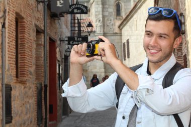 Klasik kamerayla fotoğraf çekmek için yaratıcılığını kullanan bir adam.