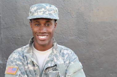 Gri duvarın önündeki yakışıklı Afro-Amerikan askerinin yakın plan portresi.