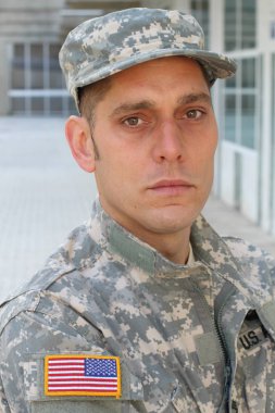 Sokaktaki üniformalı yakışıklı genç askerin yakın plan portresi.