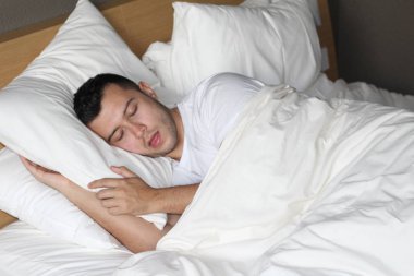 Etnik adam rahat bir yatakta derin bir uyku çekti.