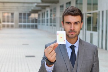 Yakışıklı genç iş adamının yakın plan portresi. Elinde kupa ası var.