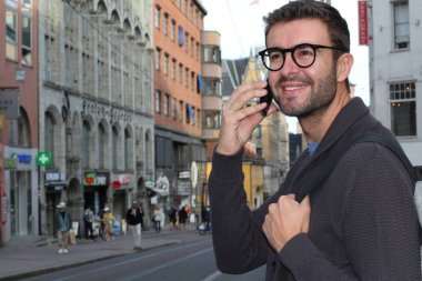 Eski Avrupa şehrinin sokaklarında günlük giysiler içinde yakışıklı bir gencin yakın plan portresi.