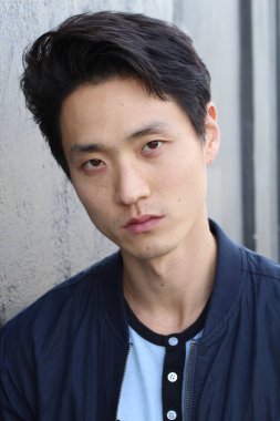 Tarafsız ifadeli Asyalı adam. Yakın plan.