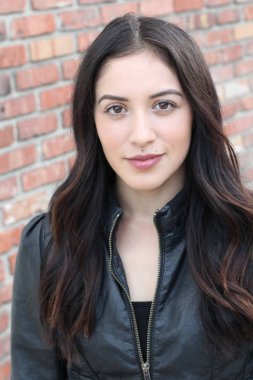 Duvarın arkasındaki kameraya bakan mükemmel kadın. 