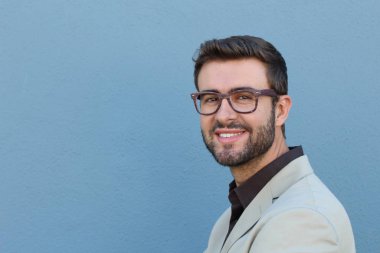 Duvarın önündeki yakışıklı sakallı adamın yakın plan portresi.