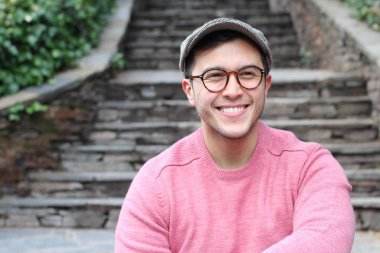 Şehir caddesinde sıradan kıyafetler giymiş yakışıklı bir gencin yakın plan portresi.