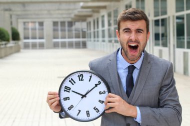 İş adamı büyük bir klasik saat tutuyor.