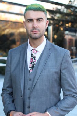 Ofiste yeşil saçlı, zarif yakışıklı bir adam.