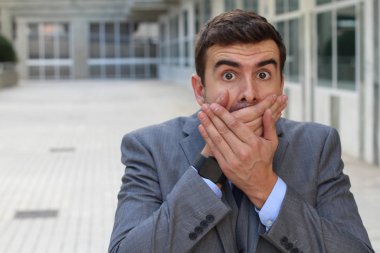 Yakışıklı genç iş adamının yakın plan portresi. Sokakta elleri ve ağzı kaplayan.