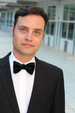 Siyah takım elbiseli, papyonlu yakışıklı bir gencin yakın plan portresi.