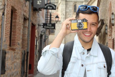 Klasik kamerayla fotoğraf çekmek için yaratıcılığını kullanan bir adam.
