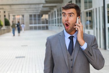 İş adamı telefonda coşkuyla dinliyor.