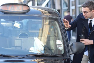 Sokakta taksiye binen yakışıklı genç adamın yakın plan portresi.