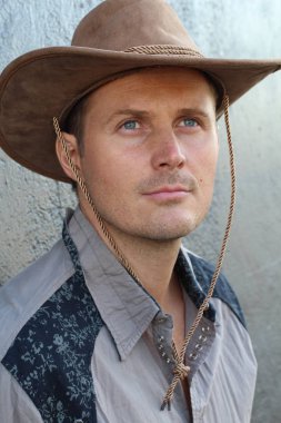 Kovboy şapkalı yakışıklı genç adamın yakın plan portresi.