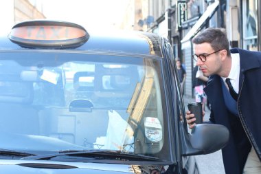 Sokakta taksiye binen yakışıklı genç adamın yakın plan portresi.