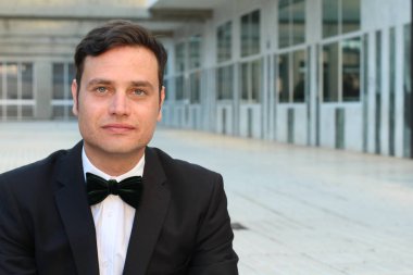 Siyah takım elbiseli, papyonlu yakışıklı bir gencin yakın plan portresi.