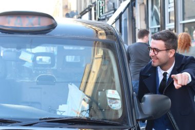 Sokakta taksiye binen yakışıklı genç adamın yakın plan portresi.