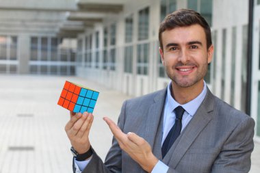 Sokakta rubik küpü tutan yakışıklı genç iş adamının yakın plan portresi.