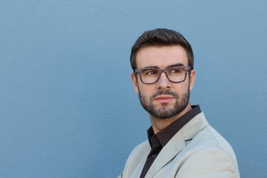 Duvarın önündeki yakışıklı sakallı adamın yakın plan portresi.