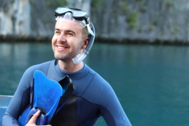 Teknede şnorkel ve maskeli yakışıklı genç adamın yakın plan portresi.