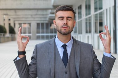 Takım elbiseli yakışıklı genç işadamının sokakta meditasyon yaparken yakın plan portresi.