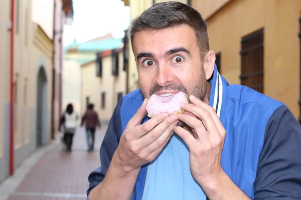 Άνθρωπος Τρώει Ένα Ντόνατ Έξω Την Ημέρα — Φωτογραφία Αρχείου