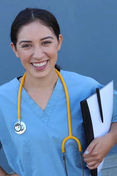 Brunette Spanish doctor woman with a stethoscope standing on blue background