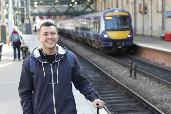 Cute ethnic young man in retro train station