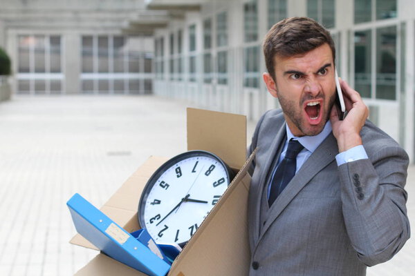 Депрессивный бизнесмен несет свои вещи
