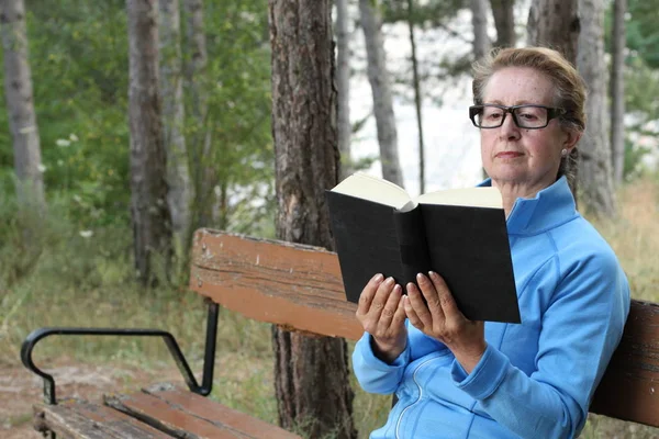 Senior Woman Relaxing Park Bench Κρατώντας Ένα Βιβλίο — Φωτογραφία Αρχείου