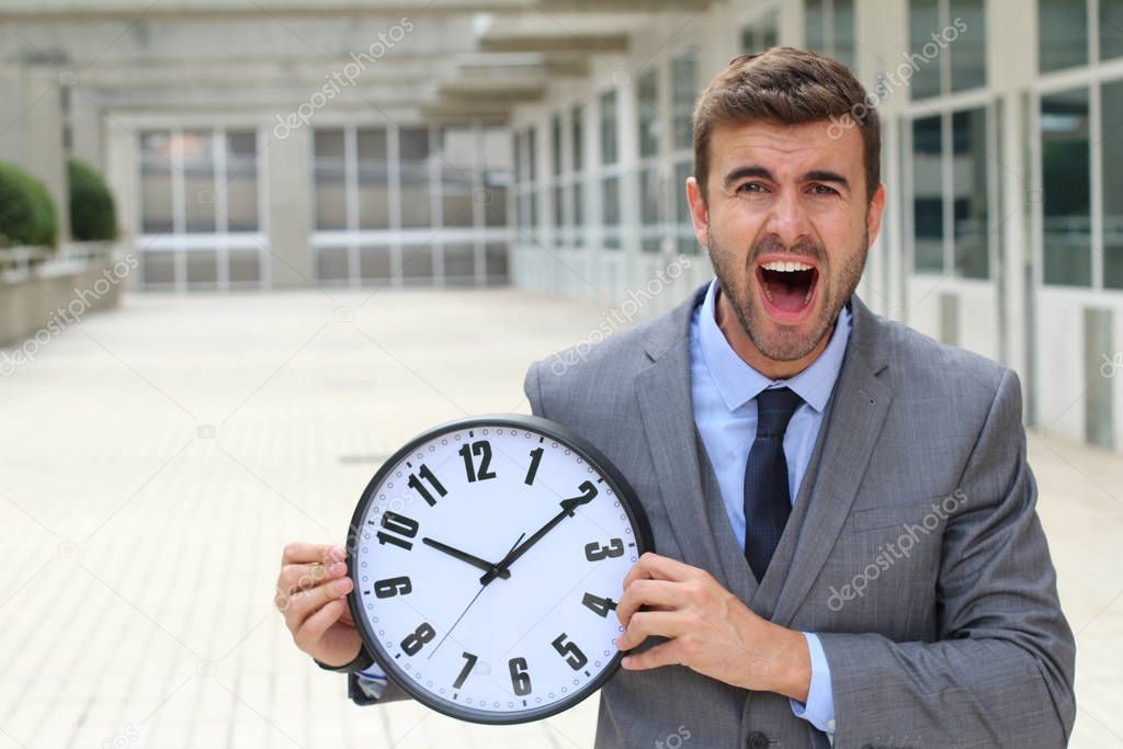Businessman holding big vintage clock