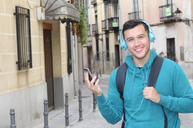 Genç etnik adam dışarıda teknoloji kullanıyor.